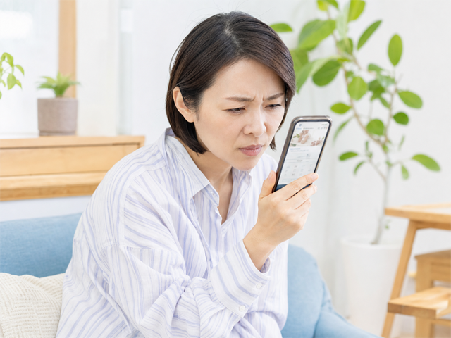 スマホで歯科医院のホームページを見て困っている患者のイメージ
